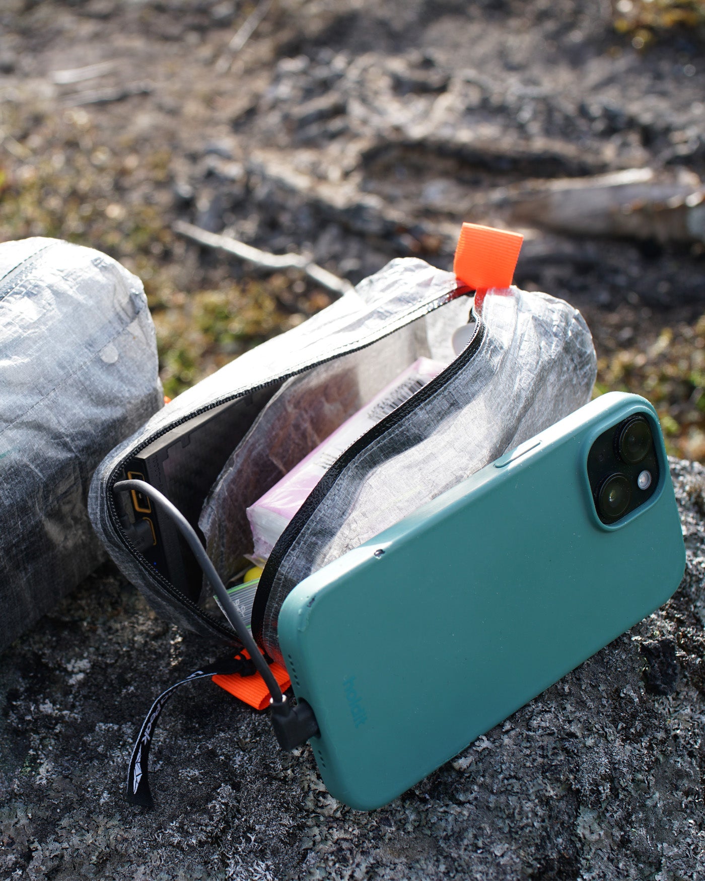 AeroStash Dyneema ditty bag holding a phone and trail electronics