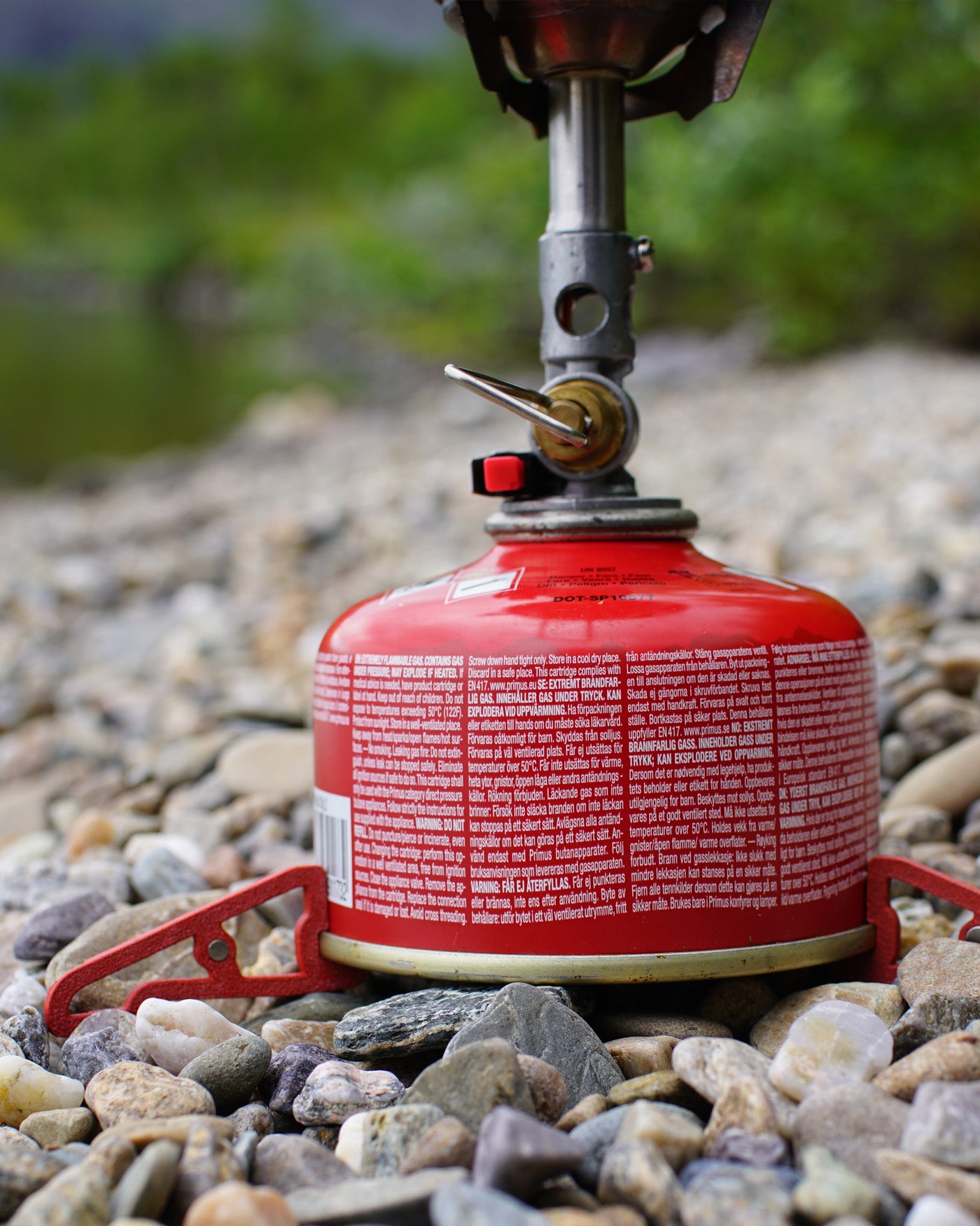 Red MagFeets stabilizing a backpacking gas canister and stove